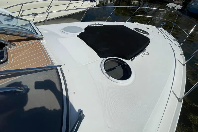 Slide: The Image of 2006 Regal Commodore 3560 IB yacht deck with portholes and railing, docked by the water. - 19