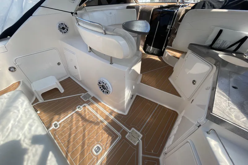 Slide: The Image of 2006 Regal Commodore 3560 IB boat interior with seating, table, and wood-patterned flooring. - 28