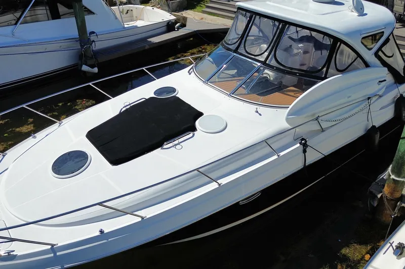 Slide: The Image of 2006 Regal Commodore 3560 IB yacht docked, featuring sleek design and spacious deck. - 3