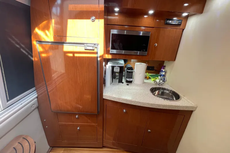 Slide: The Image of 2006 Regal Commodore 3560 IB yacht kitchen with wood cabinetry, sink, and appliances. - 46