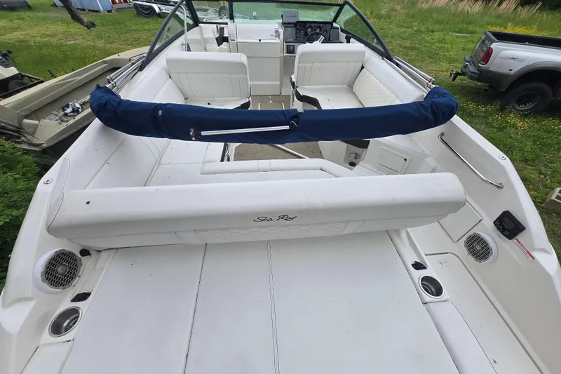 Slide: The Image of 2018 Sea Ray SDX 250 boat interior with white seating and blue cover. - 18