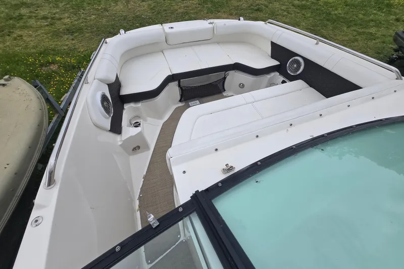 Slide: The Image of 2018 Sea Ray SDX 250 boat interior with white seating and speakers. - 19