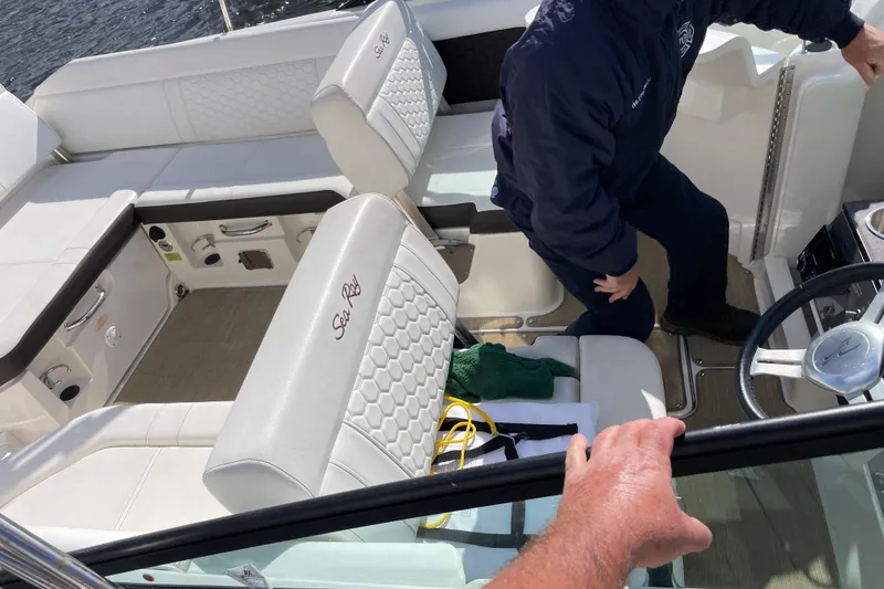 Slide: The Image of 2018 Sea Ray SDX 250 boat interior with white seating and steering wheel. - 2