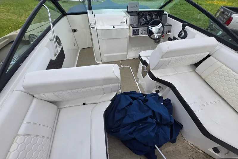 Slide: The Image of Interior of a 2018 Sea Ray SDX 250 boat with white seating and steering console. - 25