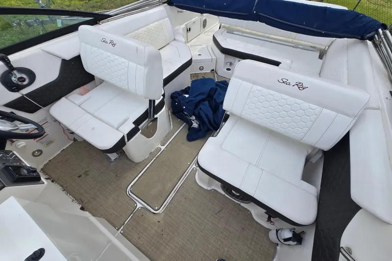 Slide: The Image of 2018 Sea Ray SDX 250 boat interior with white seating and blue cover. - 28