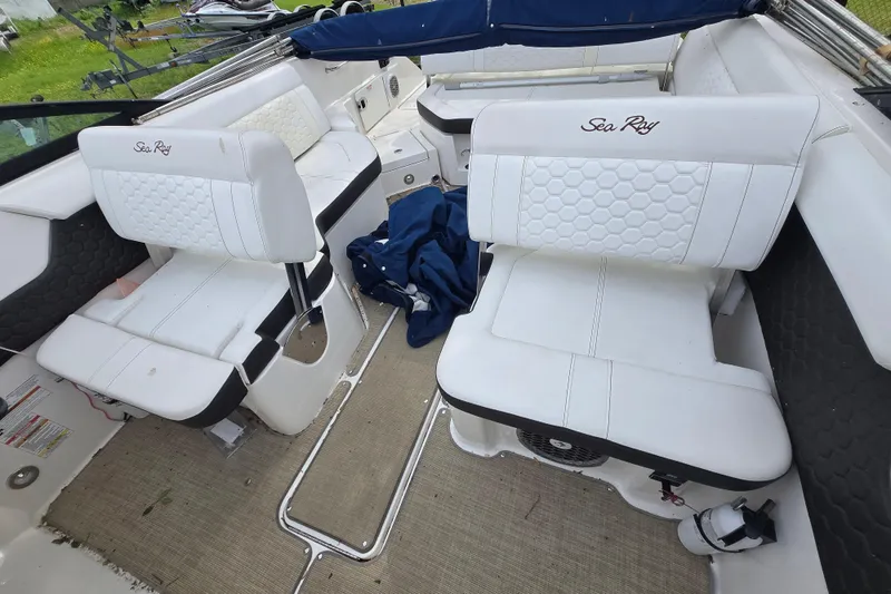 Slide: The Image of Interior of 2018 Sea Ray SDX 250 boat with white seating and blue cover. - 29