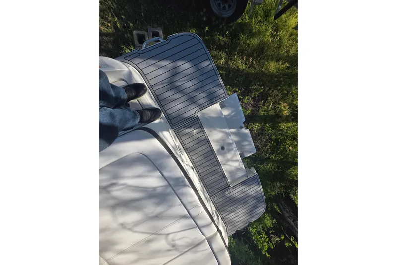 Slide: The Image of 2018 Sea Ray SDX 250 swim platform with person standing, surrounded by greenery. - 34