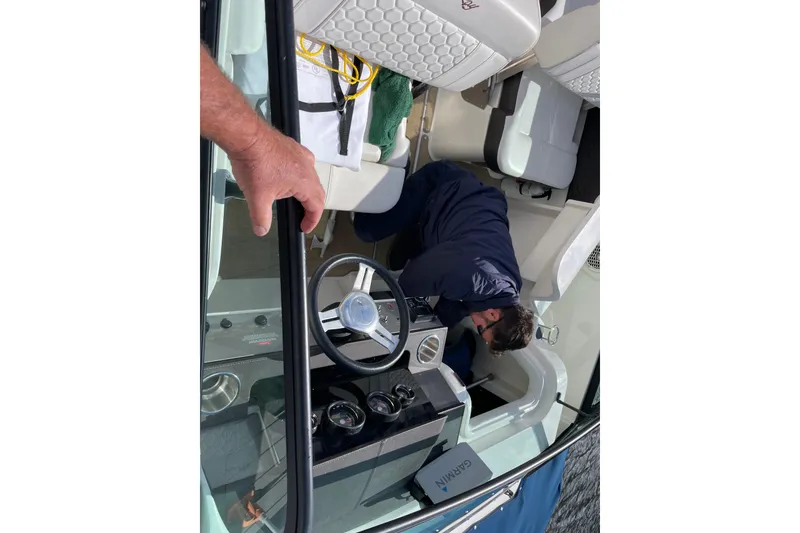 Slide: The Image of Man working inside a 2018 Sea Ray SDX 250 boat cockpit. - 6