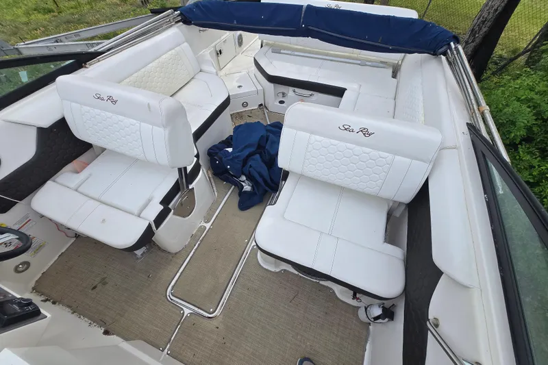 Slide: The Image of 2018 Sea Ray SDX 250 boat docked with blue cover, residential waterfront background. - 8