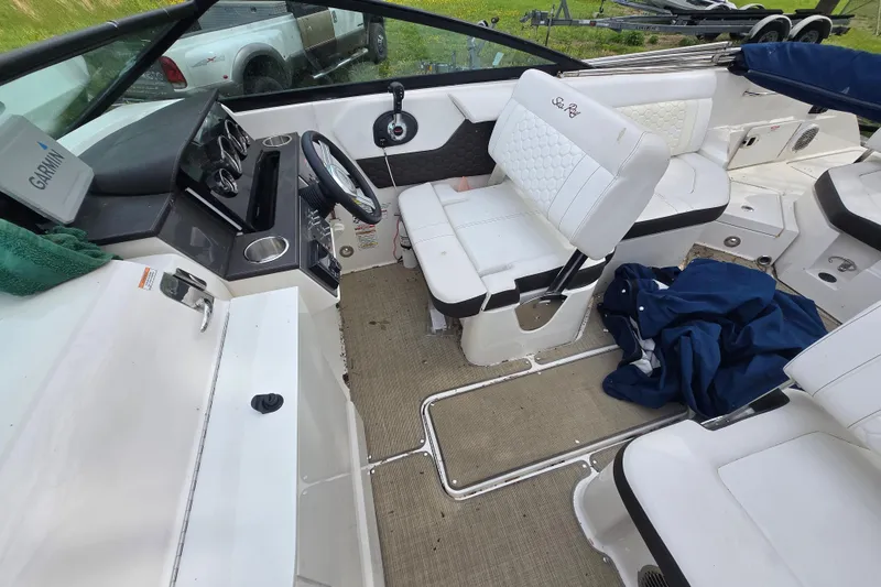 Slide: The Image of Interior of 2018 Sea Ray SDX 250 boat with white seating and steering console. - 9