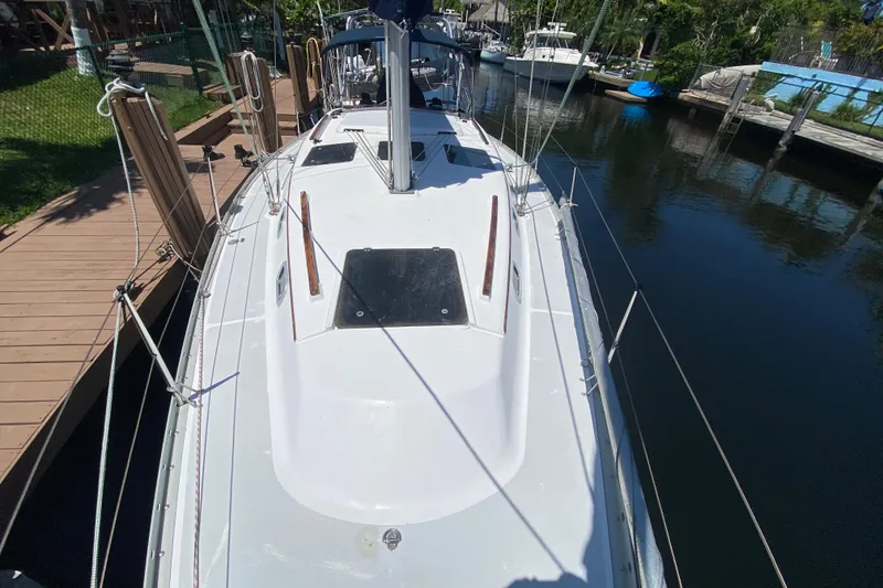 Slide: The Image of Hunter 33.5 sailboat from 1995 docked in a marina, viewed from the deck. - 13