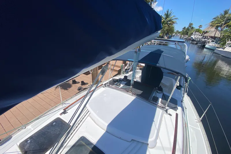 Slide: The Image of 1995 Hunter 33.5 sailboat docked in a sunny marina, featuring blue canvas covers. - 14