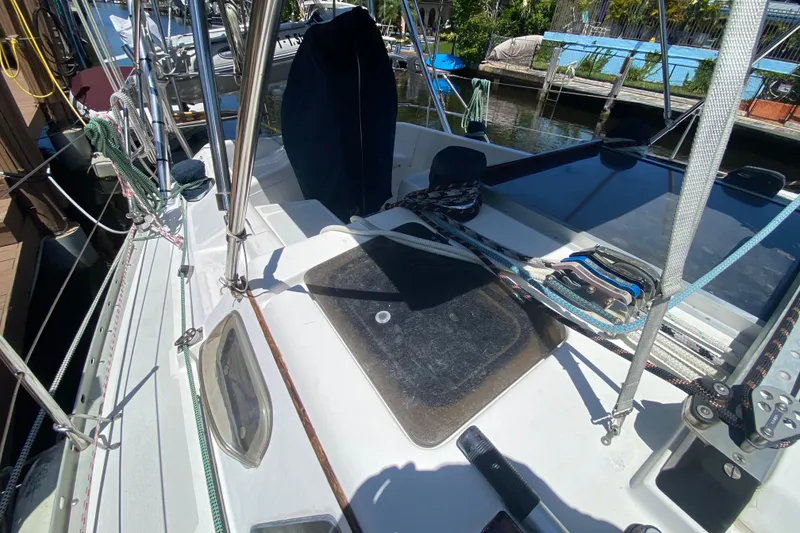 Slide: The Image of 1995 Hunter 33.5 sailboat deck with ropes and hatch, docked by the water. - 15