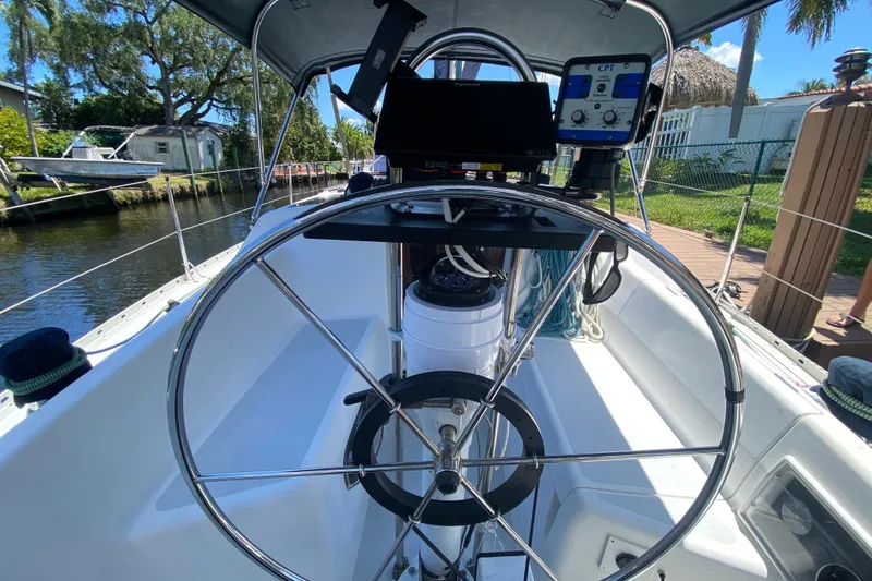 Slide: The Image of Cockpit view of a 1995 Hunter 33.5 sailboat with steering wheel and navigation equipment. - 19