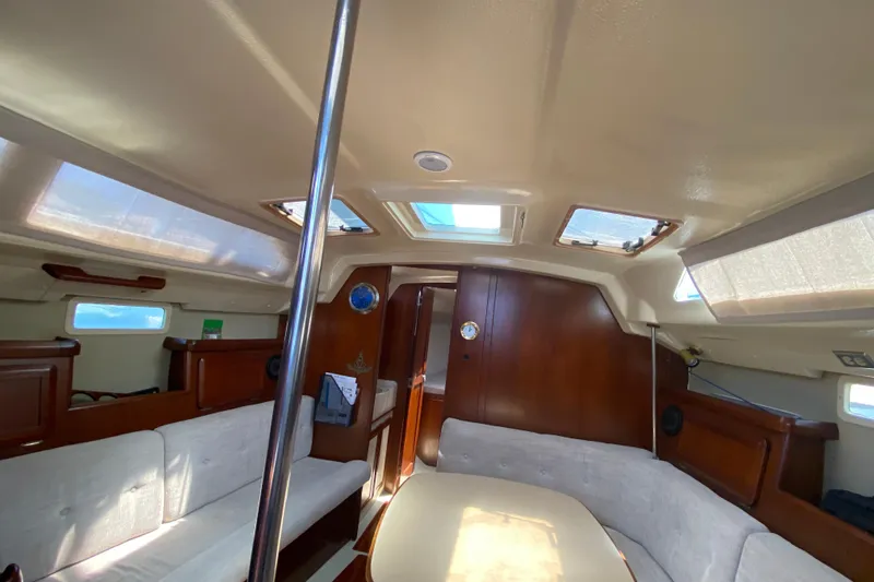 Slide: The Image of Interior of a 1995 Hunter 33.5 sailboat with wood finish and seating area. - 25
