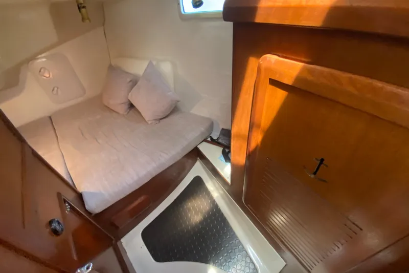 Slide: The Image of Cozy cabin interior of 1995 Hunter 33.5 sailboat with wooden finishes and bedding. - 26
