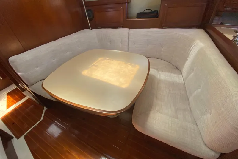 Slide: The Image of Cozy dining area in a 1995 Hunter 33.5 sailboat with cushioned seating and wooden accents. - 29