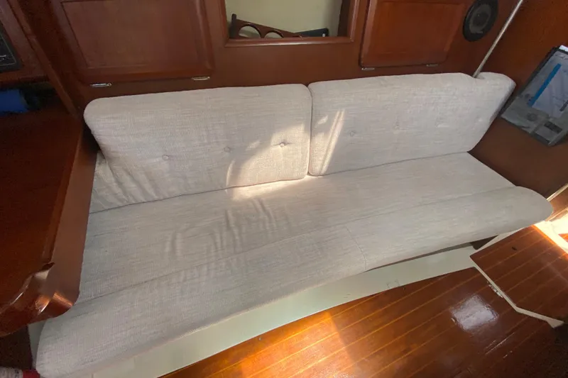 Slide: The Image of Interior of a 1995 Hunter 33.5 sailboat with a beige cushioned sofa. - 32