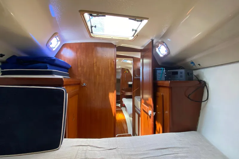 Slide: The Image of Interior of a 1995 Hunter 33.5 sailboat, featuring wood paneling and compact cabin space. - 36
