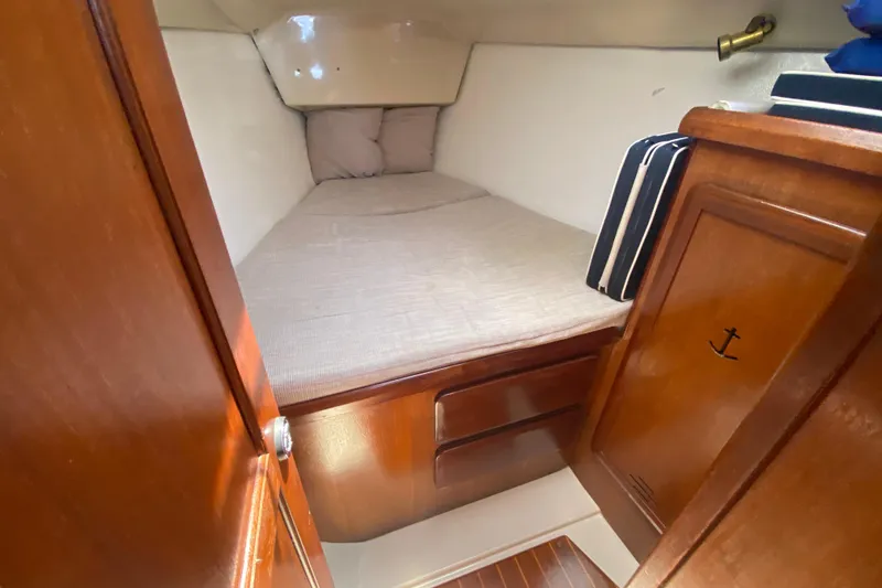 Slide: The Image of Cozy cabin interior of a 1995 Hunter 33.5 sailboat with wooden finish and bedding. - 38