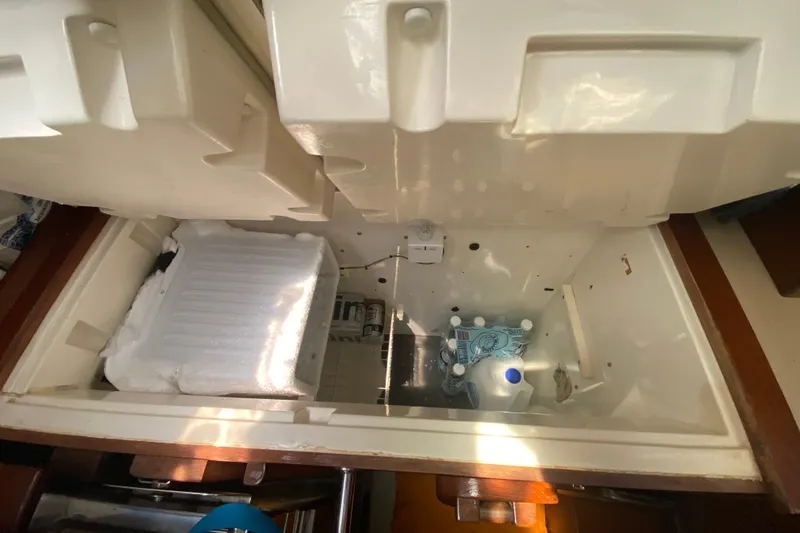 Slide: The Image of Interior view of a 1995 Hunter 33.5 sailboat's storage compartment with water bottles. - 51