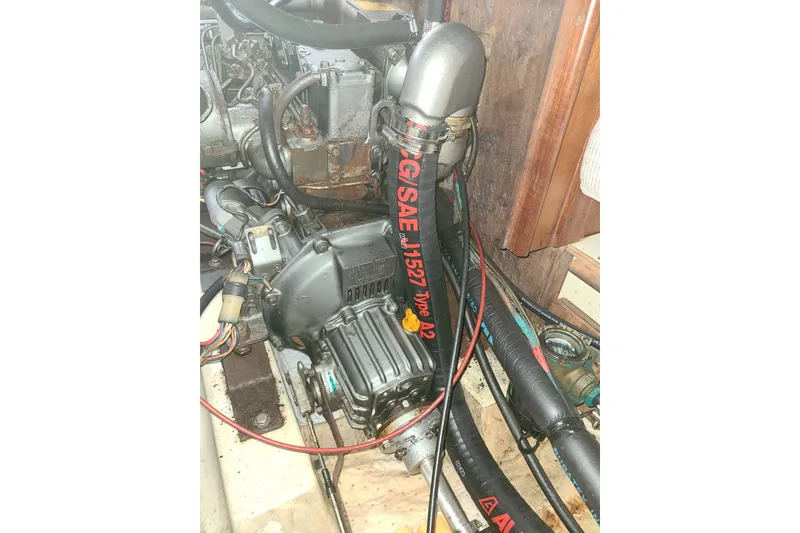 Slide: The Image of Engine compartment of a 1995 Hunter 33.5 sailboat, featuring hoses and mechanical components. - 54