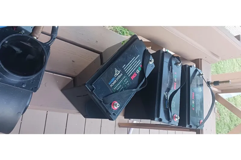 Slide: The Image of Three black batteries on a wooden deck, related to a 1995 Hunter 33.5 model. - 60