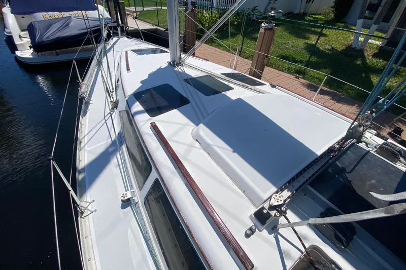 Slide: The Image of 1995 Hunter 33.5 sailboat docked, showcasing deck and rigging details. - 8