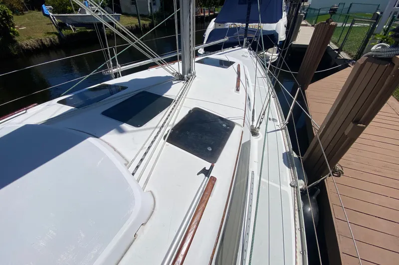 Slide: The Image of 1995 Hunter 33.5 sailboat docked, showcasing deck and rigging details. - 9