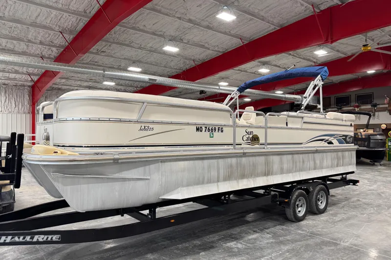 The Image of 2006 G3 Sun Catcher LX325 pontoon boat on trailer in indoor storage facility. - 1