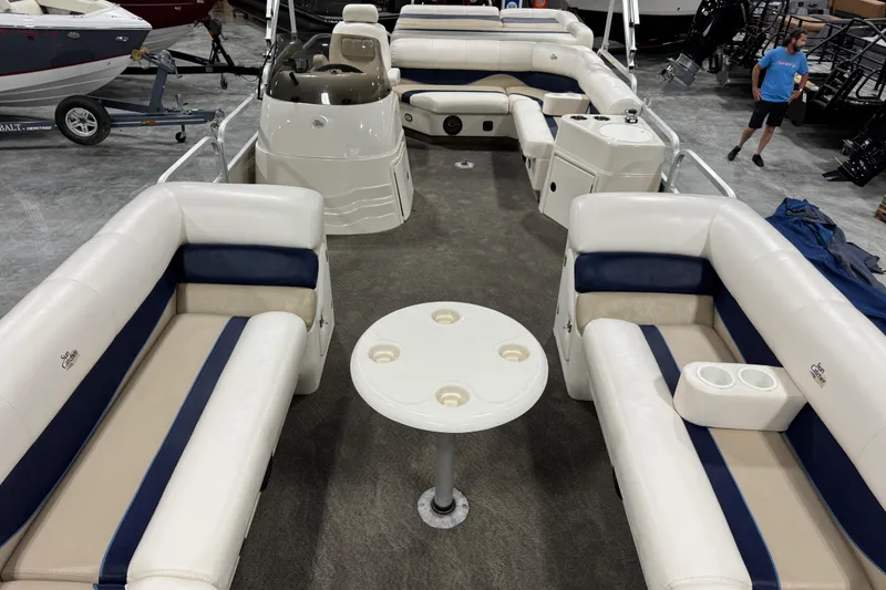 Slide: The Image of Interior of a 2006 G3 pontoon boat with beige and blue seating and a round table. - 7