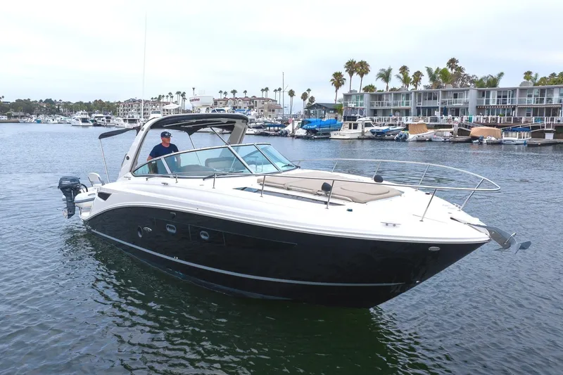The Image of 2015 Sea Ray Sundancer 350 yacht in harbor, modern architecture in background. - 0