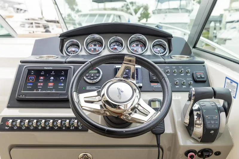 Slide: The Image of Cockpit of 2015 Sea Ray Sundancer 350 with steering wheel and control panel. - 16