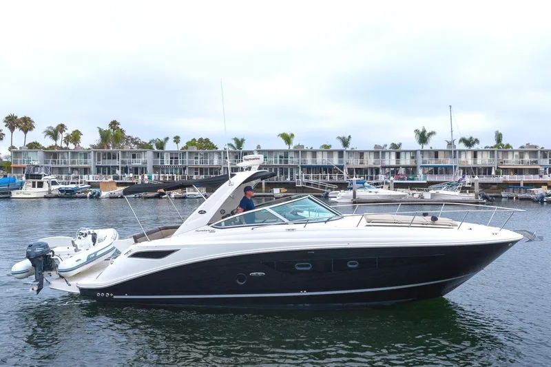 Slide: The Image of 2015 Sea Ray Sundancer 350 yacht docked in harbor with modern buildings. - 2