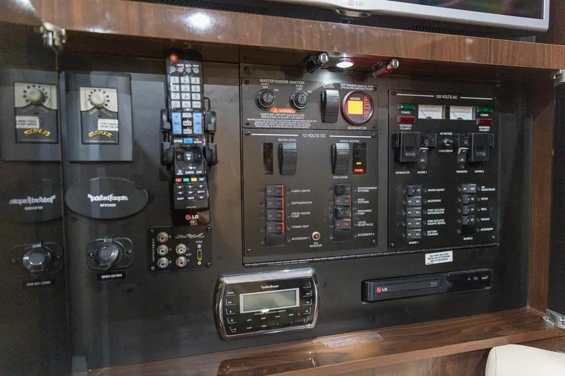 Slide: The Image of Control panel of a 2015 Sea Ray Sundancer 350 yacht with various switches and remotes. - 26