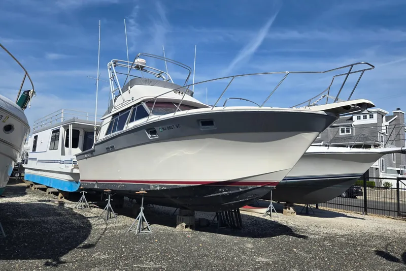 Slide: The Image of 1988 Silverton 34 Convertible boat on stands, clear sky background. - 10