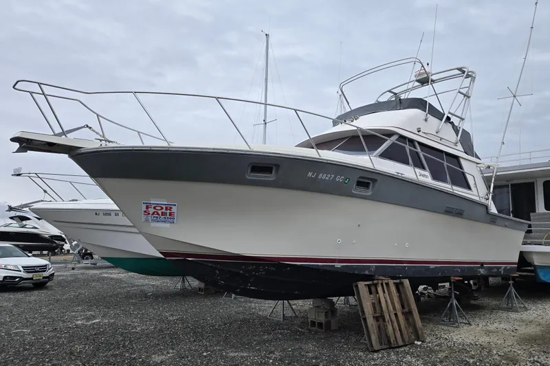 Slide: The Image of 1988 Silverton 34 Convertible boat for sale, displayed on land with a "For Sale" sign. - 11