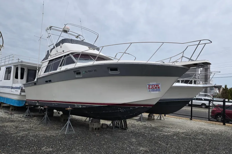Slide: The Image of 1988 Silverton 34 Convertible boat for sale, displayed on stands in a marina. - 14