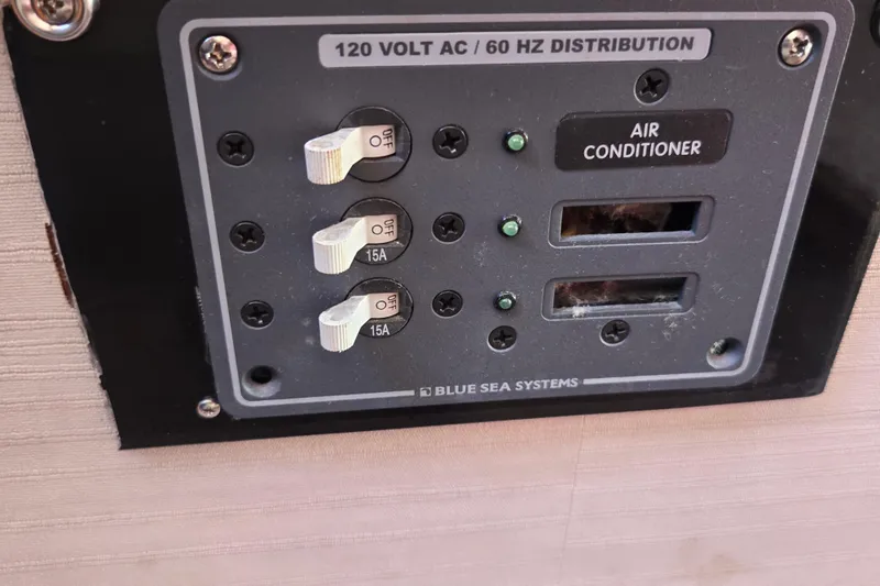 Slide: The Image of Electrical panel on a 1988 Silverton 34 Convertible boat, featuring circuit breakers and air conditioner controls. - 20