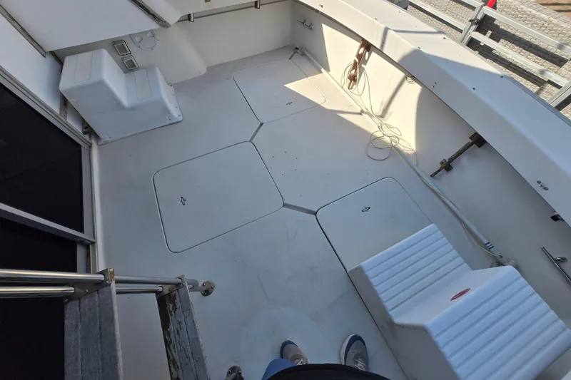 Slide: The Image of 1988 Silverton 34 Convertible boat deck with storage hatches and seating. - 24