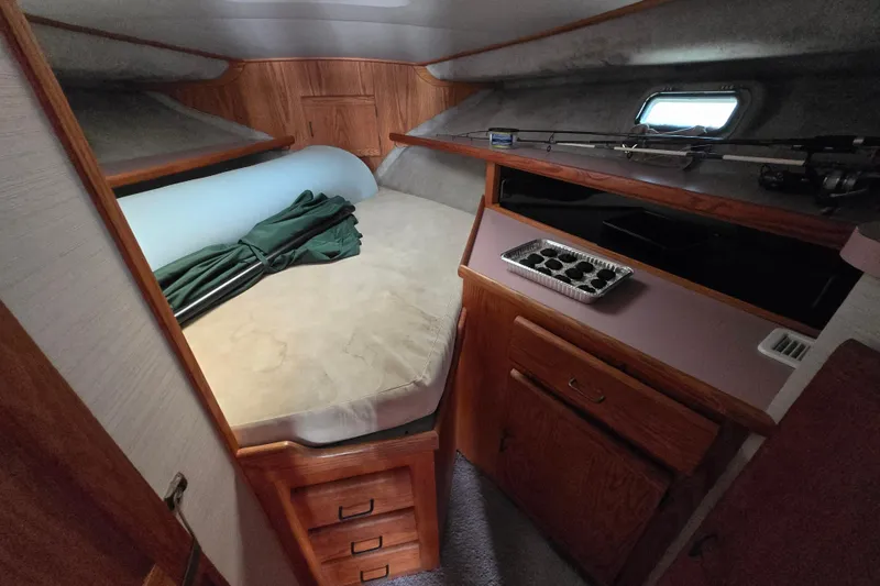 Slide: The Image of Cozy cabin interior of 1988 Silverton 34 Convertible boat with bed and storage. - 5