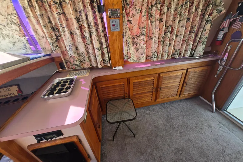 Slide: The Image of Interior of a 1988 Silverton 34 Convertible with floral curtains and wooden cabinetry. - 8