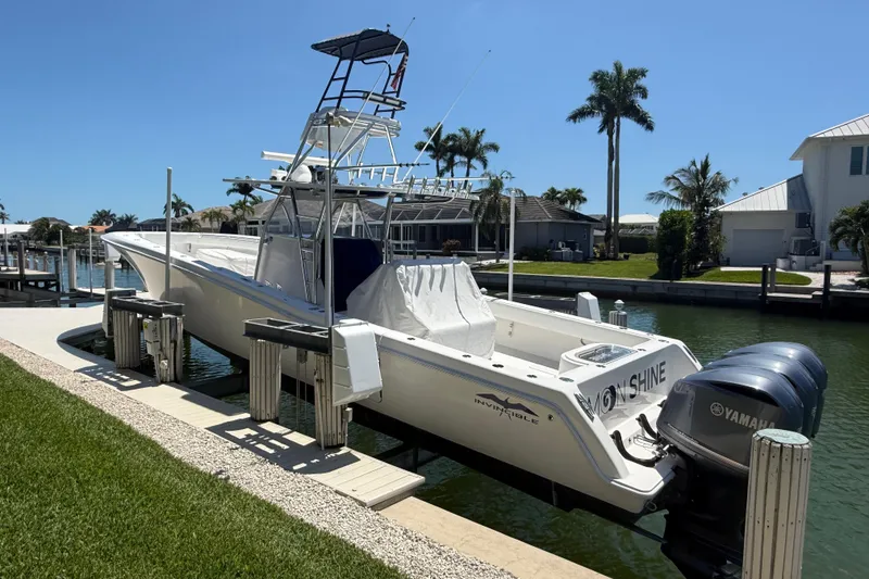 The Image of 2012 Invincible 42 Open Fisherman boat docked, featuring Yamaha engines, in a sunny waterfront setting. - 1