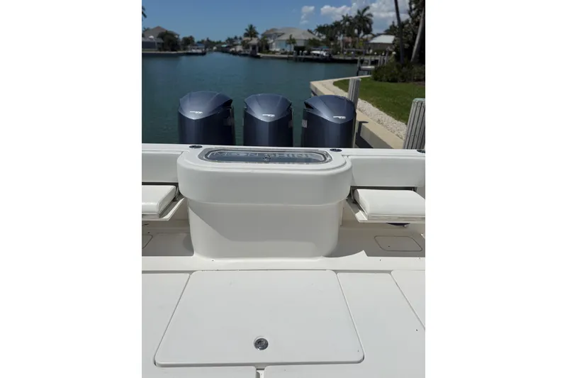 Slide: The Image of 2012 Invincible 42 Open Fisherman boat with triple outboard engines docked by a canal. - 20
