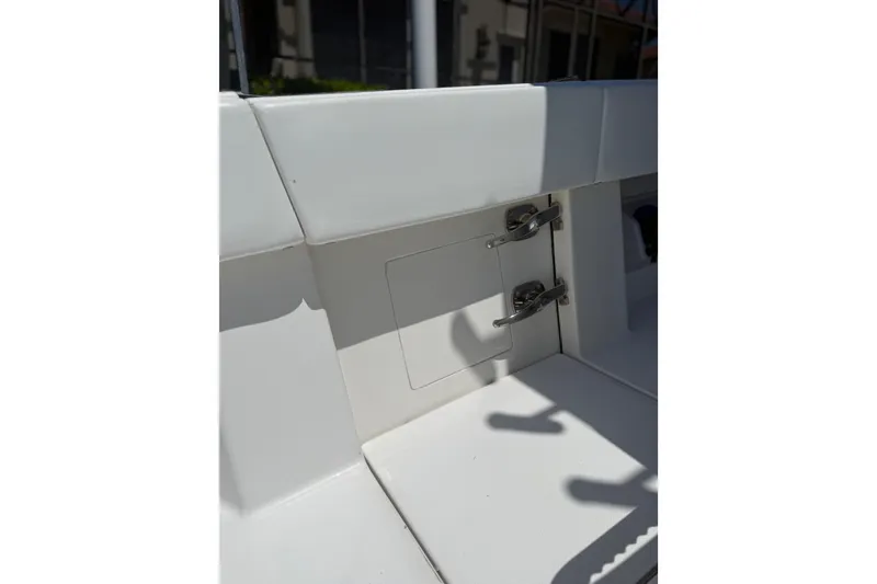 Slide: The Image of 2012 Invincible 42 Open Fisherman boat interior detail with storage compartment and metal latches. - 23