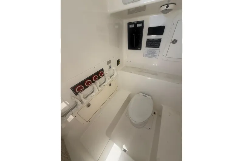 Slide: The Image of Interior of 2012 Invincible 42 Open Fisherman boat, featuring a compact marine toilet. - 24