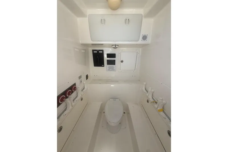 Slide: The Image of Interior of 2012 Invincible 42 Open Fisherman boat, featuring a compact marine toilet. - 25