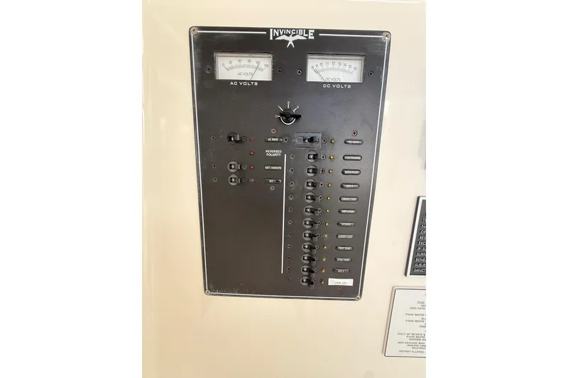 Slide: The Image of Electrical panel of a 2012 Invincible 42 Open Fisherman boat, showing AC and DC volt meters. - 26