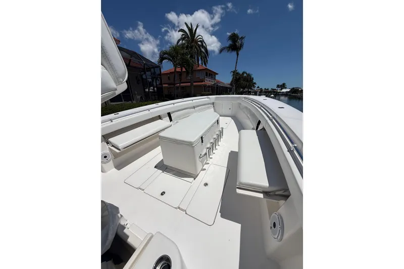 Slide: The Image of 2012 Invincible 42 Open Fisherman boat interior with seating and storage under a clear blue sky. - 29