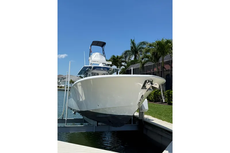 Slide: The Image of 2012 Invincible 42 Open Fisherman boat docked near waterfront homes. - 3